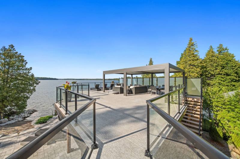 A large deck with benches and a gazebo overlooking the water.