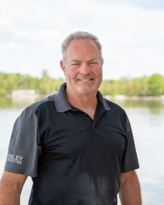 A man standing in front of the water.